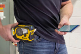 Man with the M211 printer clipped to his belt prints a label using a mobile app.