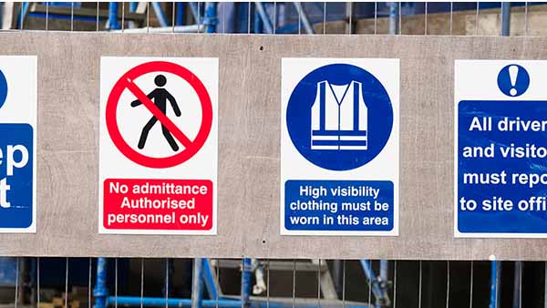Construction site health and safety signage outlines rules on the construction site fence boundary.