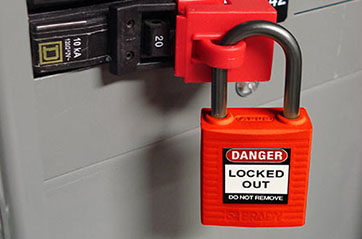 Lockout device attached to a breaker panel completing the LOTOTO process.
