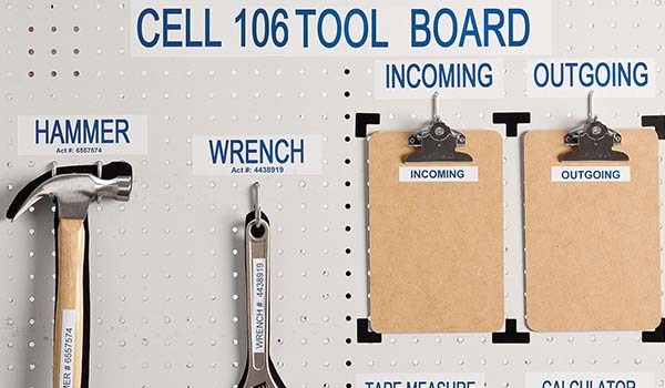Backdrop of a handyman bench with a wrench, hammer, tape measure, calculator, and two clip boards hanging.