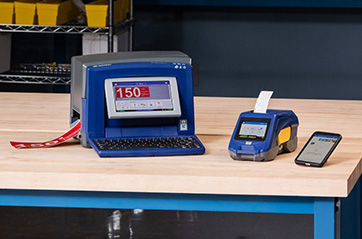 An assortment of Brady printers on a workbench,