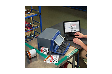 A person at a workstation with a hazardous material printer.