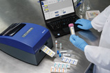 A laboratory technician prints custom labels for vials and tubes using the Brady J2000 label printer.