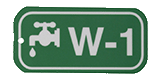 Close-up image of a green and white valve tag labeled W-1 for water identification.