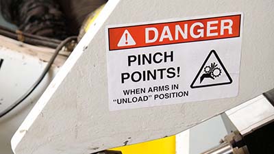 A label with a preprinted danger header is customized for a pinch point warning.