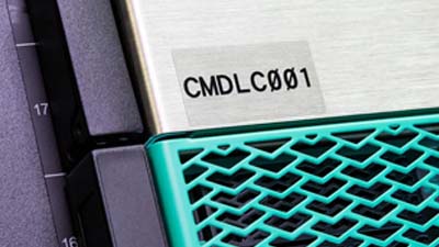 A machine piece with a polyester label that is transparent with black text.