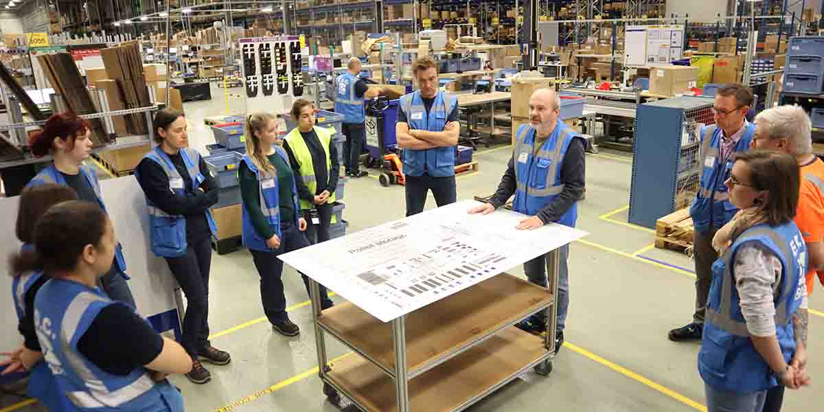 A team meeting of workers in a warehouse facility.